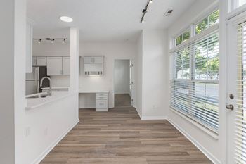 A kitchen with white walls and a large window